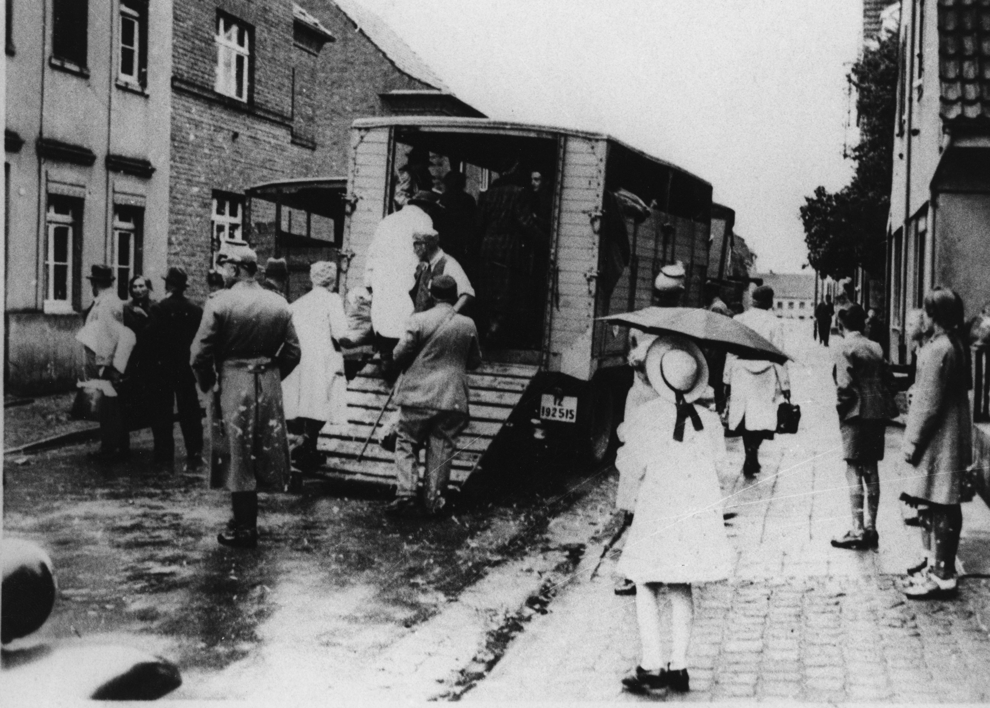 Przechodnie widzą Żydów wprowadzanych przez policję do ciężarówki w celu deportacji. Kerpen, Nadrenia Północna-Westfalia, 1942. Fot. Stadtarchiv Kerpen